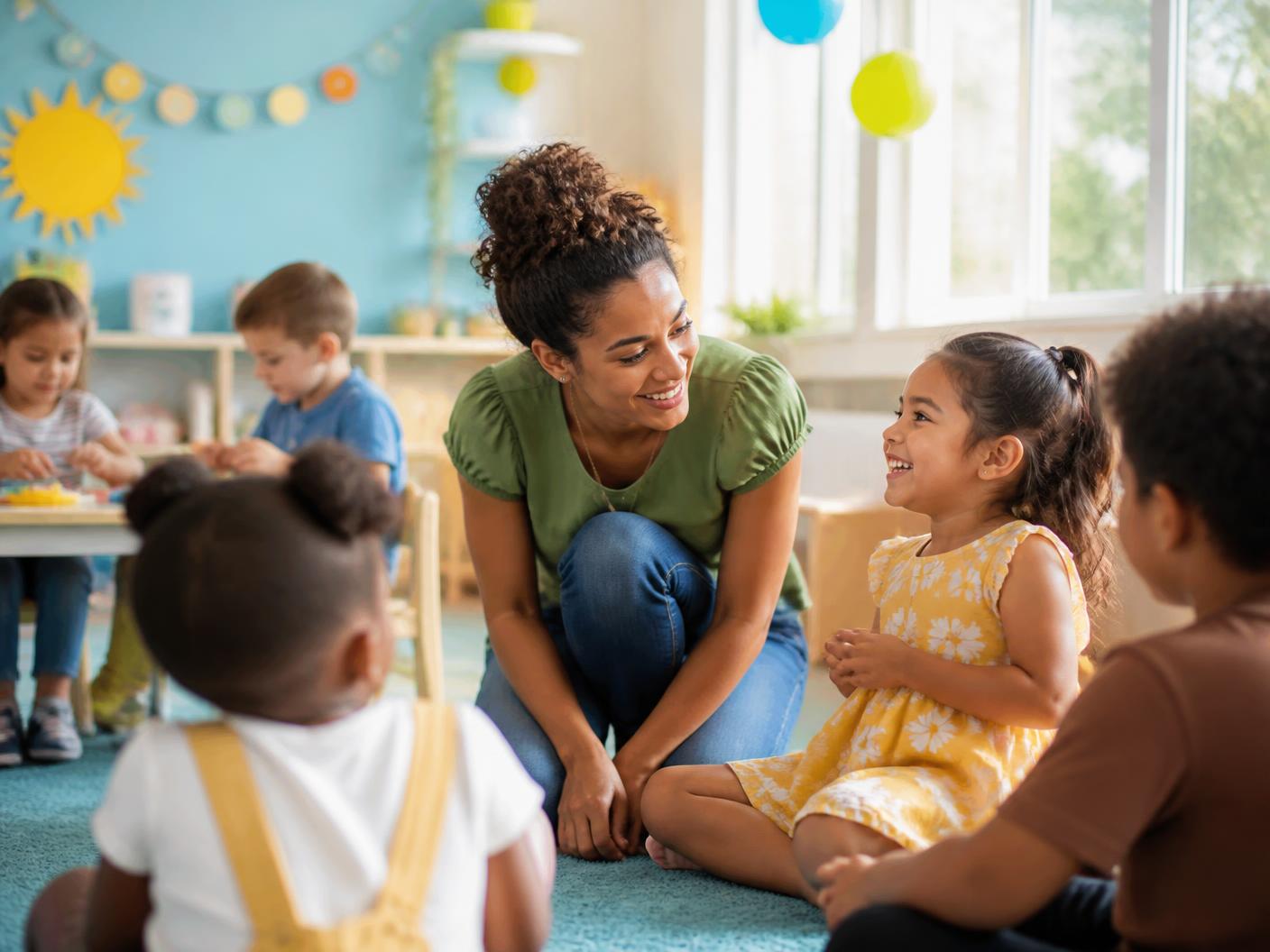 Children and teachers gathered for a warm classroom celebration with simple decorations and natural lighting